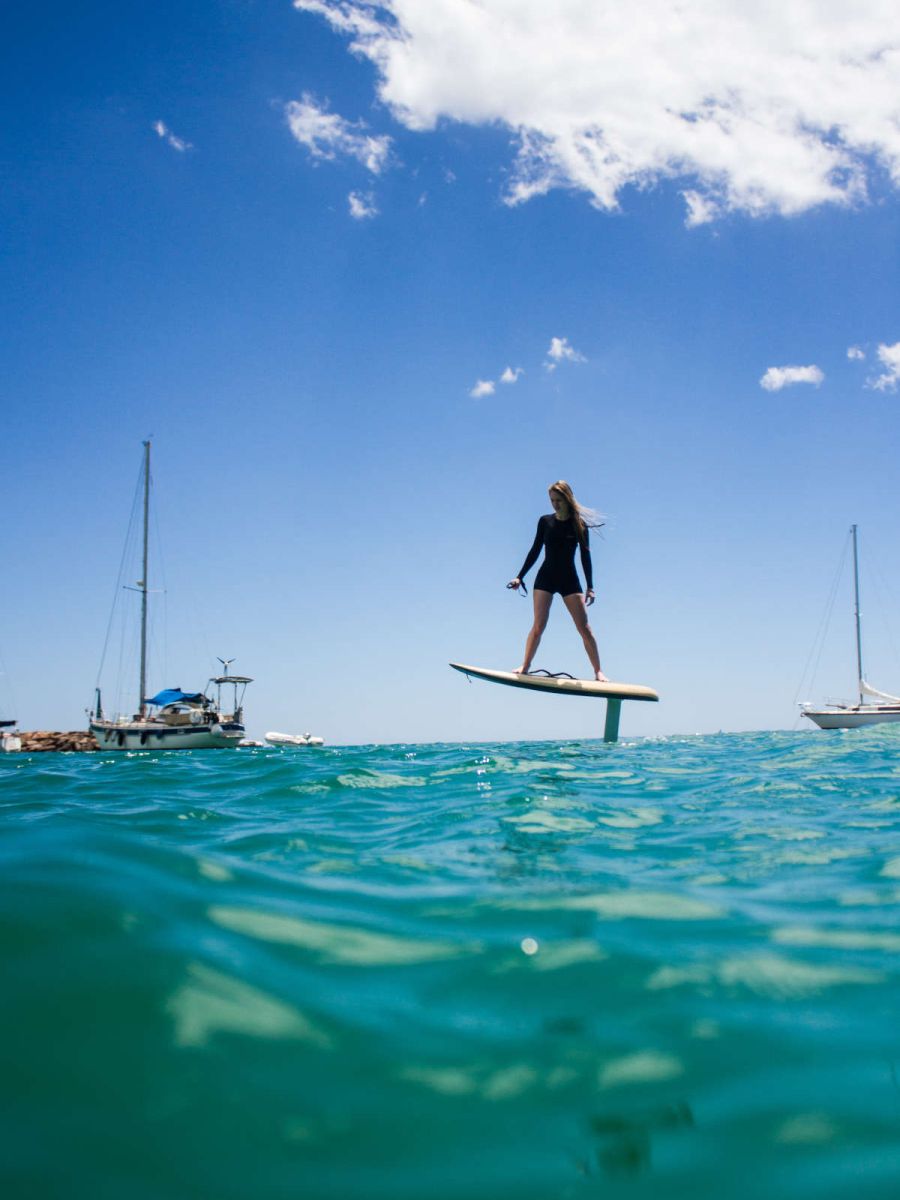 Mujer sobre una tabla propulsada en el mar